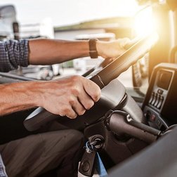 Männer Arme die ein Lastkraftwagen Lenkrad festhalten